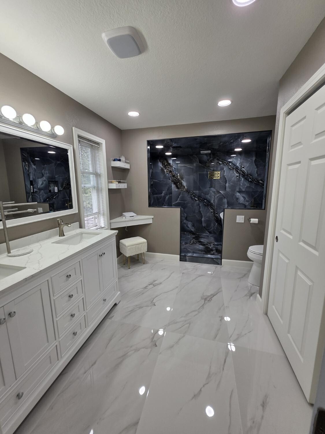 Finished primary bath with marble floor and stone wet room