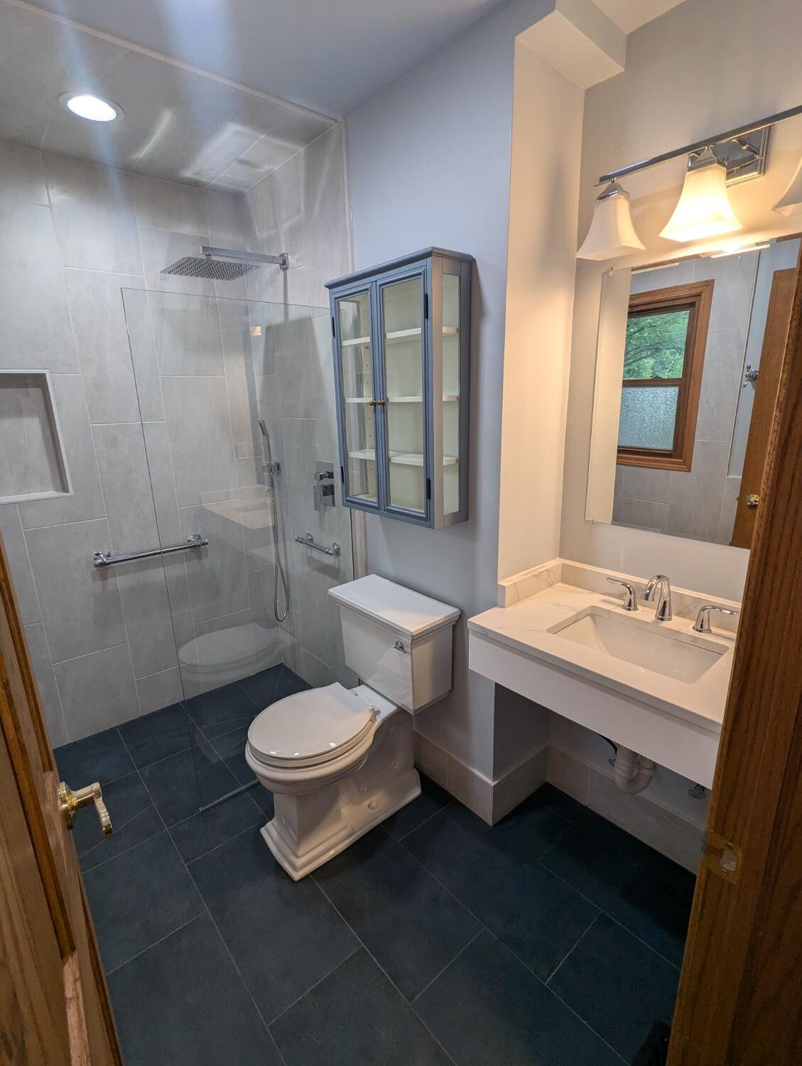Gray tile walk-in with glass and rain head