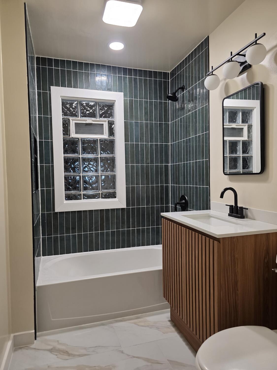 Green stacked tile tub with slatted wood vanity