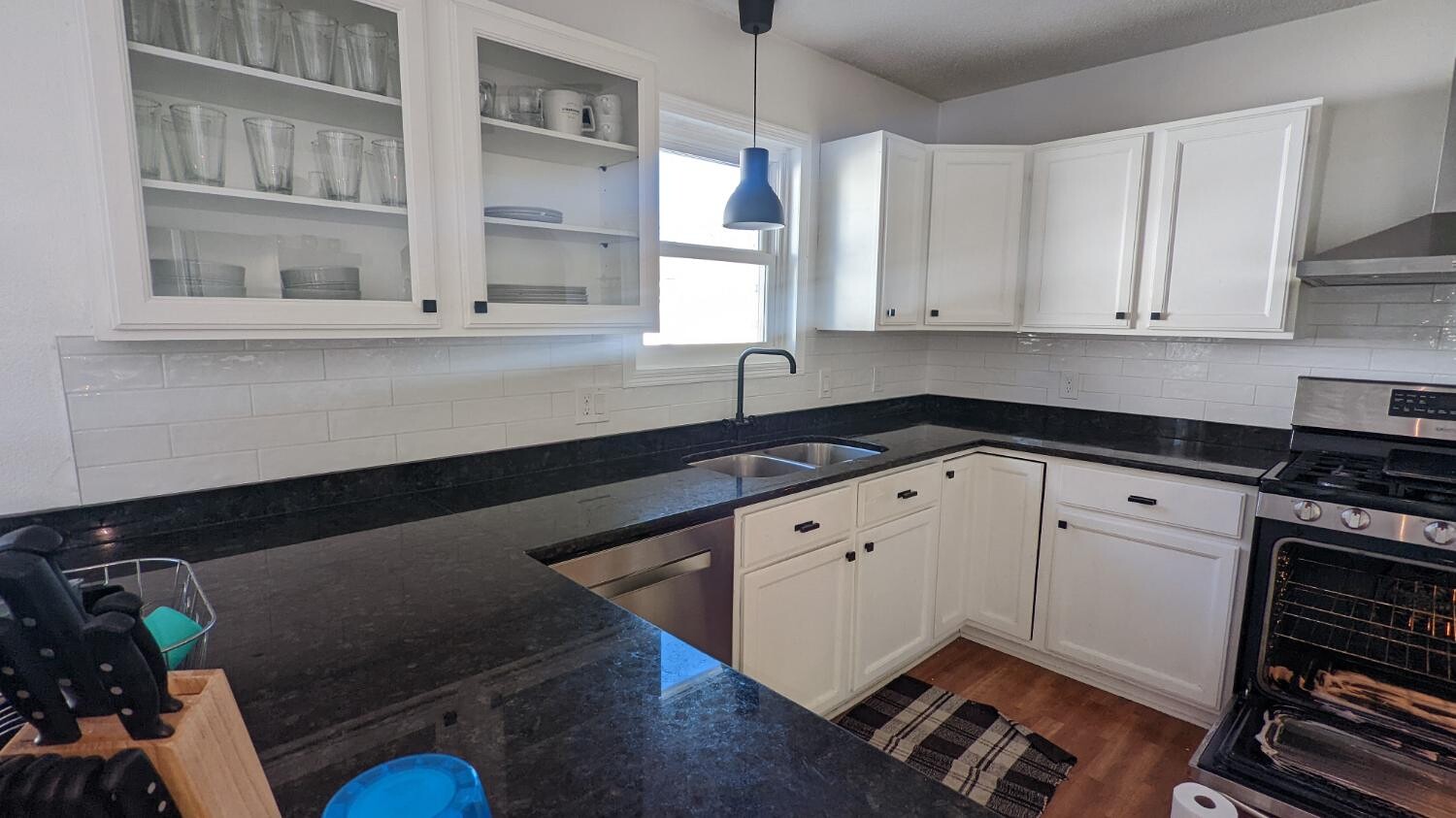 White kitchen with black granite and glass-front cabinets