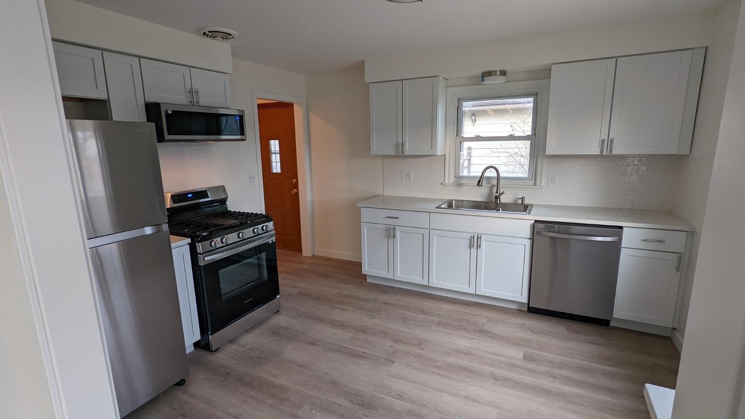 White galley kitchen with stainless appliances