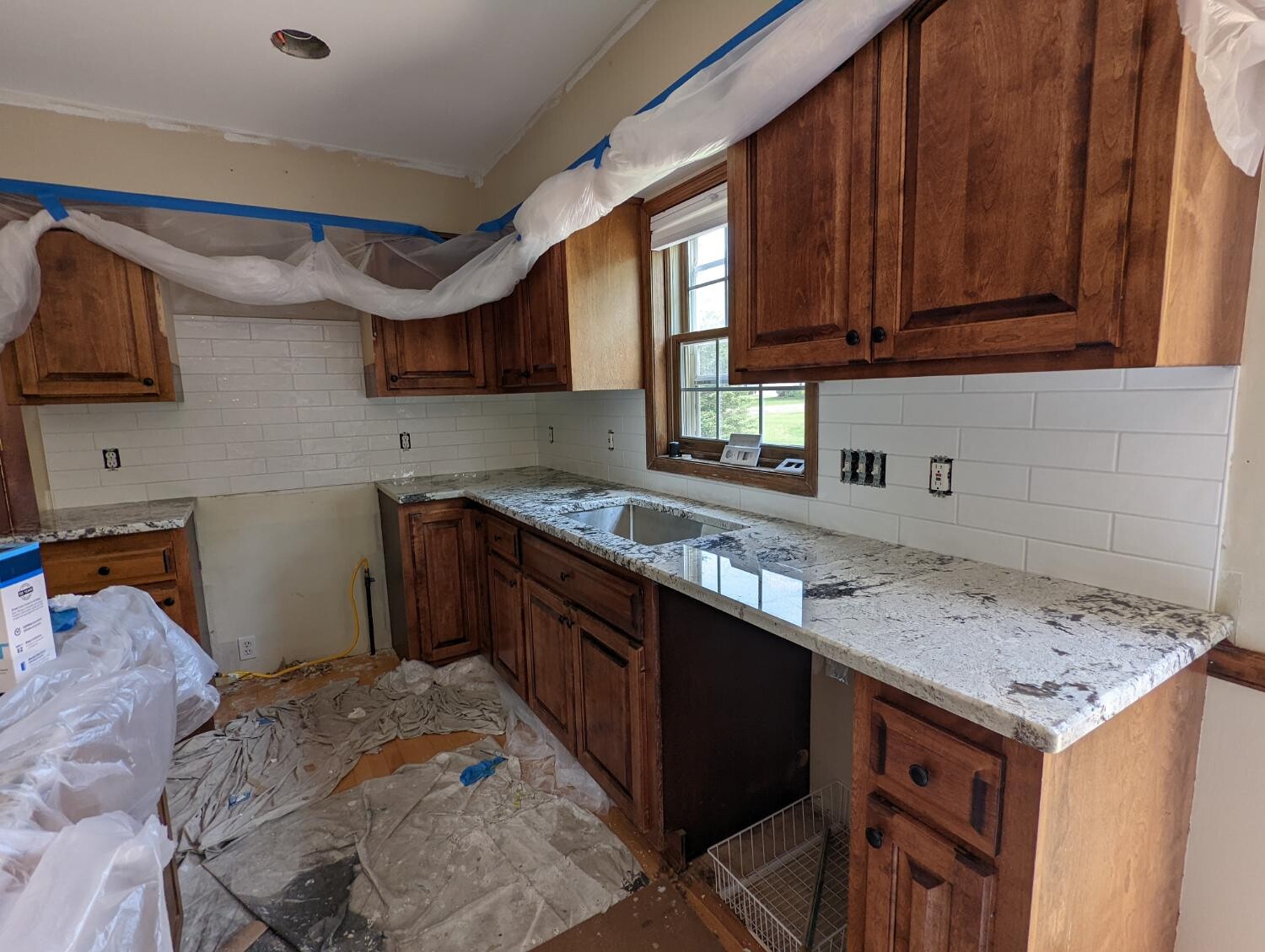 Stained oak kitchen with granite counters and subway tile